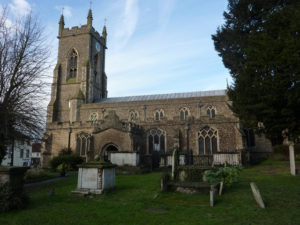 A photograph of St Andrew's church, Halstead, showing some of the graves in the churchyard.