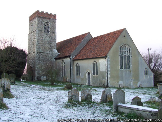 A photograph of the old church of St Mary's in Belstead, in the snow. Some stone headstones are in the foreground.